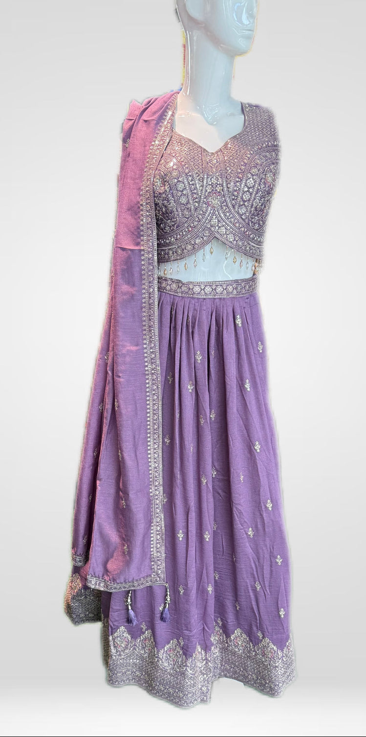 Purple embroidered dress on a mannequin against a white background