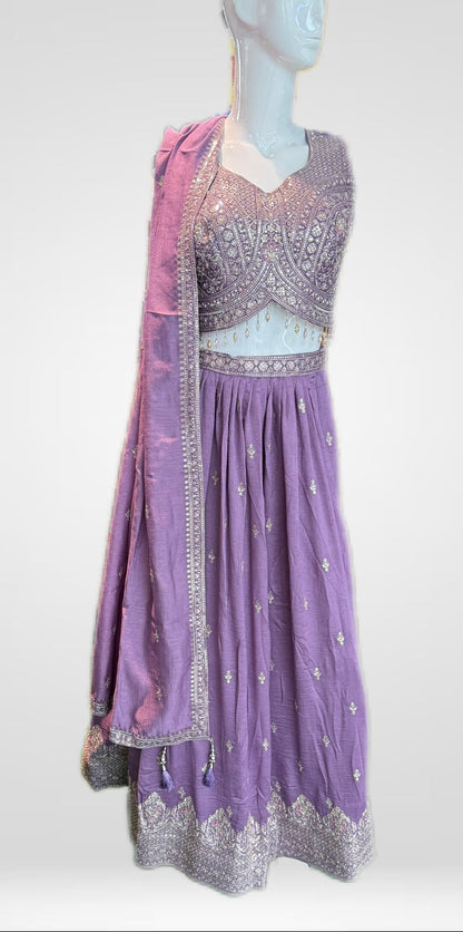 Purple embroidered dress on a mannequin against a white background